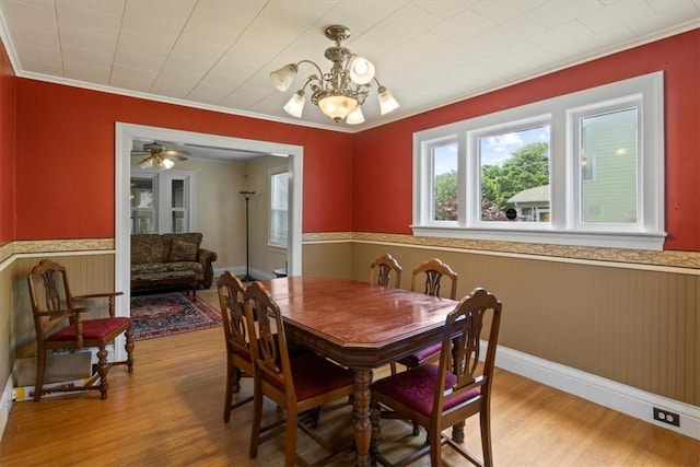 dining room featuring ceiling fan with notable chandelier, light hardwood / wood-style flooring, and crown molding