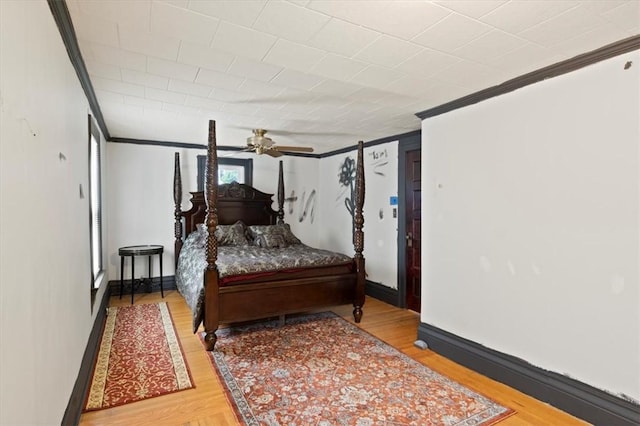 bedroom with hardwood / wood-style floors, ceiling fan, and ornamental molding