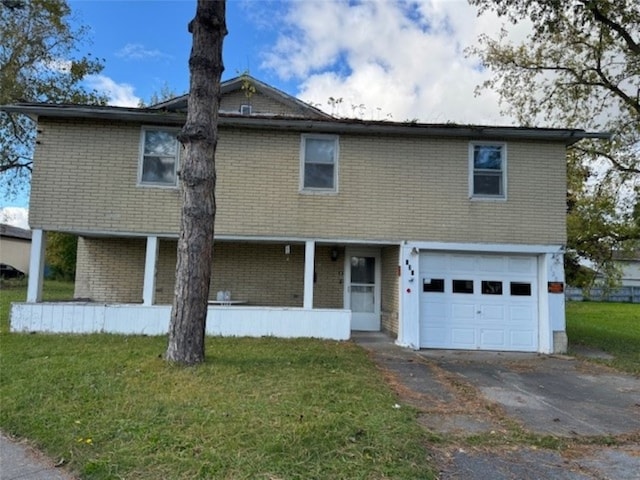 view of front of house featuring covered porch, a front yard, and a garage