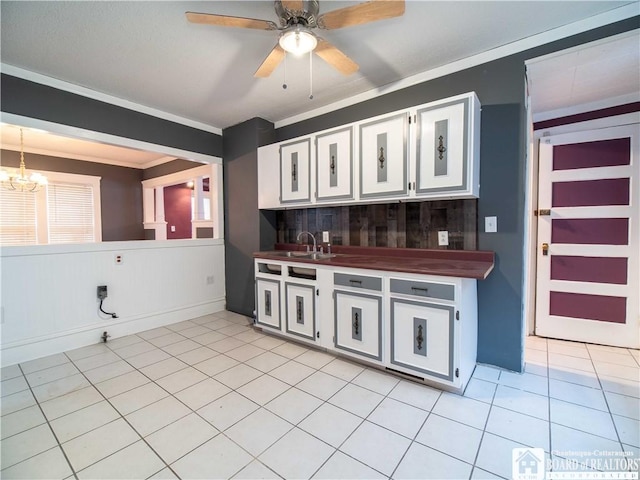 kitchen featuring ceiling fan with notable chandelier, white cabinetry, ornamental molding, and light tile patterned flooring