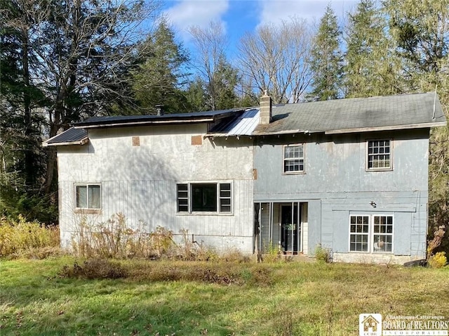 rear view of property with a yard