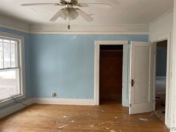 empty room with ceiling fan and wood-type flooring