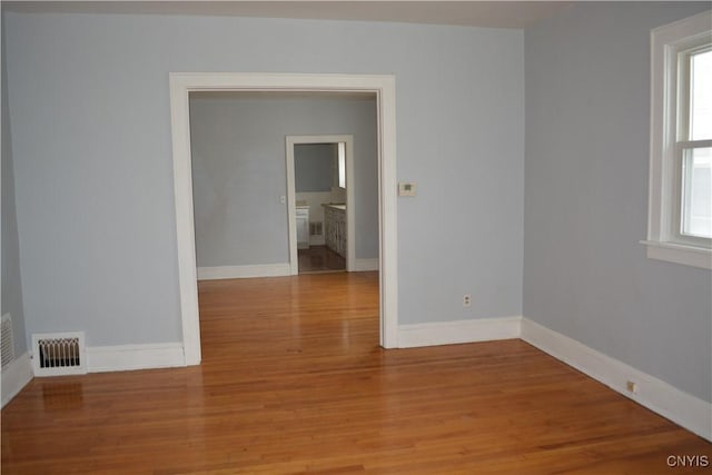 unfurnished room featuring a wealth of natural light and light hardwood / wood-style floors