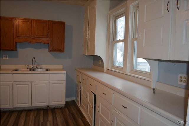 kitchen featuring dark hardwood / wood-style floors, white cabinetry, and sink