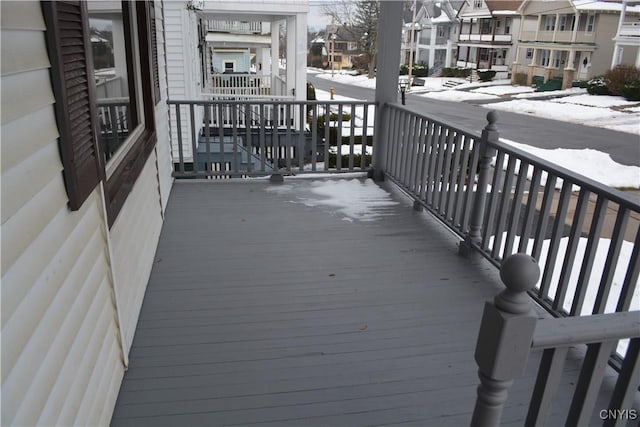 snow covered back of property featuring a porch