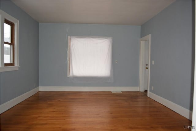 empty room with wood-type flooring and a wealth of natural light