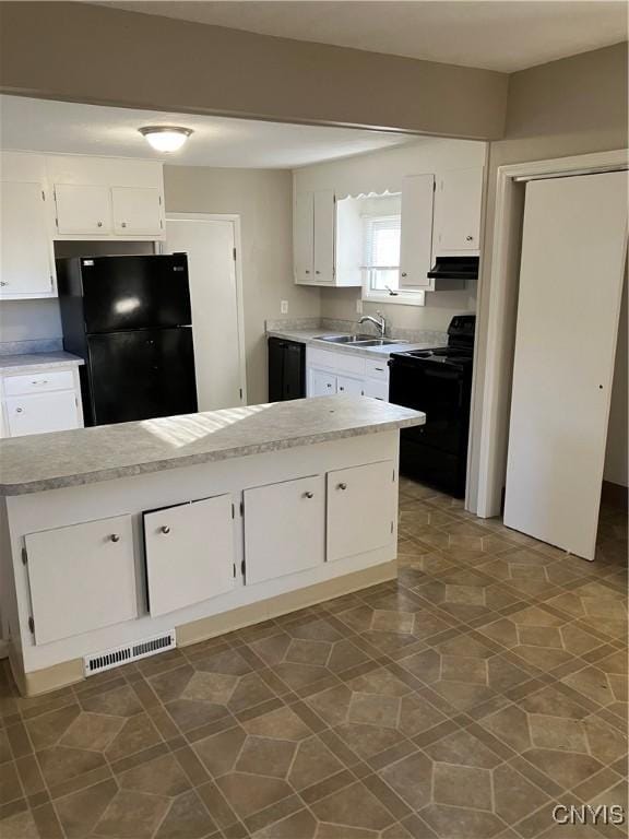 kitchen with black appliances, white cabinetry, and sink