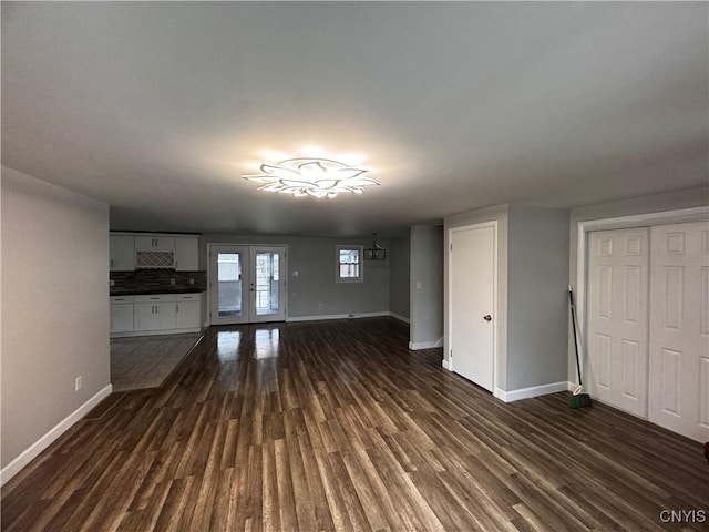 unfurnished living room featuring french doors and dark hardwood / wood-style floors