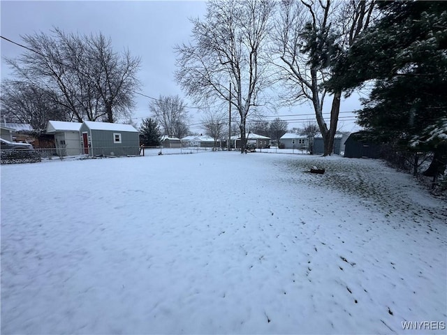 snowy yard featuring an outbuilding