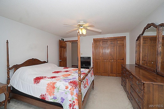 carpeted bedroom featuring ceiling fan, a textured ceiling, and a closet