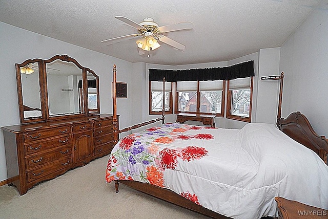 bedroom with ceiling fan, a textured ceiling, and carpet flooring