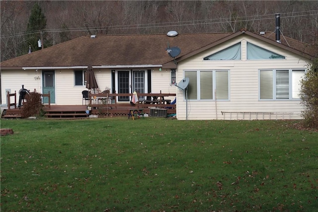 rear view of property featuring a yard and a deck