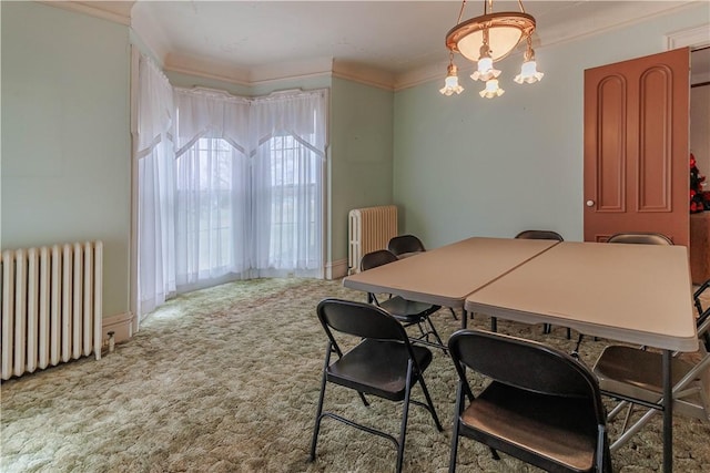 carpeted dining room with ornamental molding, radiator, and a notable chandelier