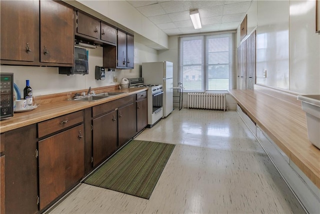 248 W Ave, Clarkson, NY 14420 - kitchen with white gas stove, radiator heating unit, dark brown cabinets, light countertops, and a paneled ceiling