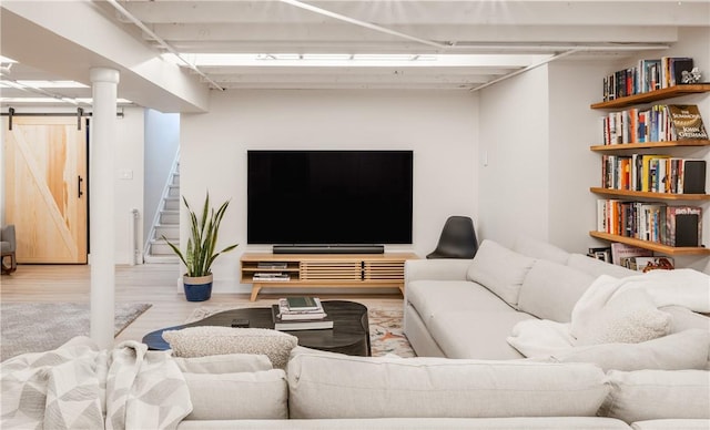 living room with a barn door and light hardwood / wood-style flooring