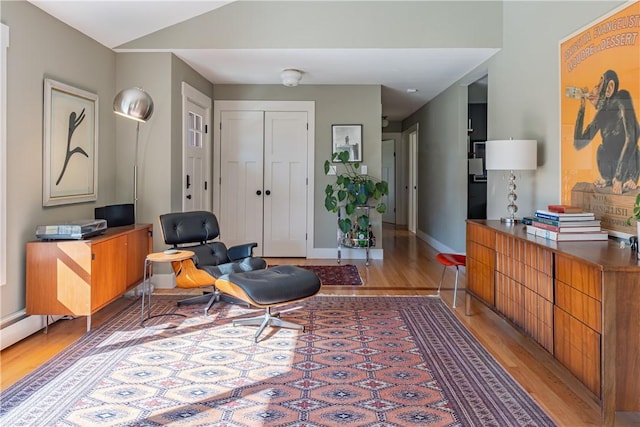 sitting room with light wood-type flooring and lofted ceiling