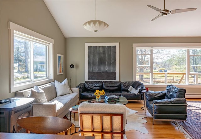 living room featuring ceiling fan, light hardwood / wood-style floors, vaulted ceiling, and a baseboard heating unit