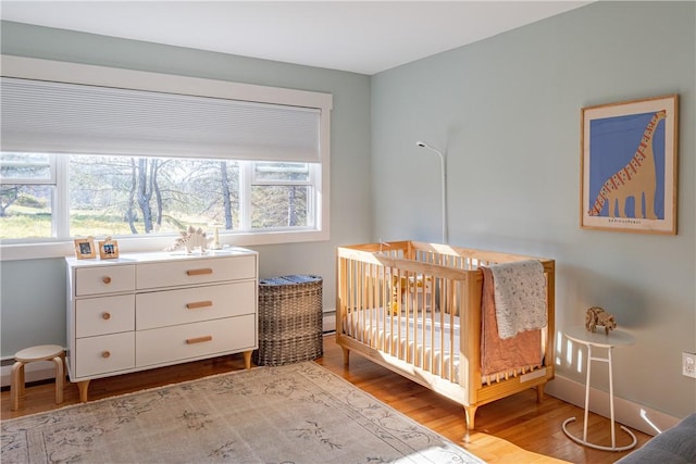 bedroom with wood-type flooring and a crib