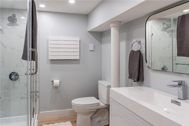 bathroom featuring vanity, a shower with shower door, radiator, toilet, and wood-type flooring