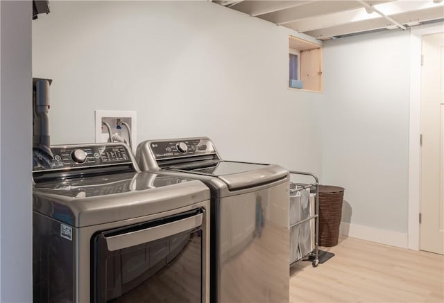 washroom featuring light hardwood / wood-style floors and washer and clothes dryer