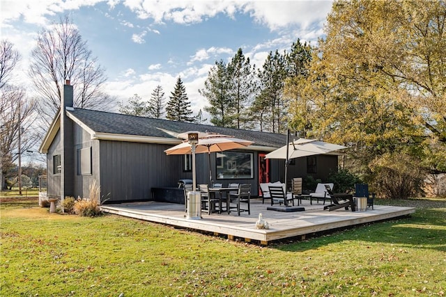 back of property featuring a lawn and a deck