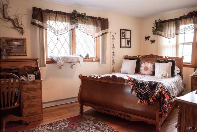 bedroom featuring a baseboard radiator and wood finished floors