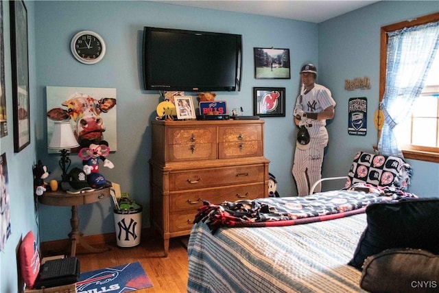 bedroom featuring light wood finished floors and baseboards