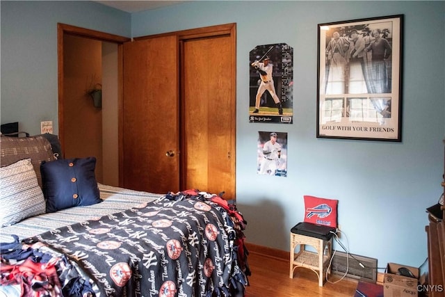 bedroom with a closet, baseboards, and wood finished floors