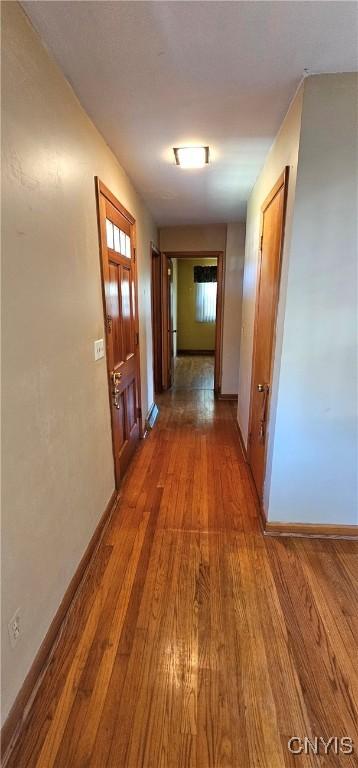 hallway with baseboards and wood finished floors