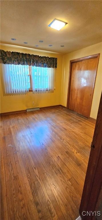 unfurnished room featuring visible vents, baseboards, and wood finished floors