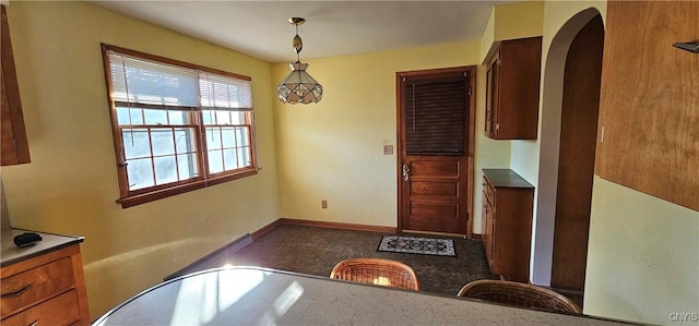 dining area with arched walkways and baseboards