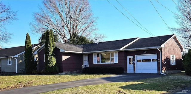 ranch-style home with driveway, a front yard, and an attached garage