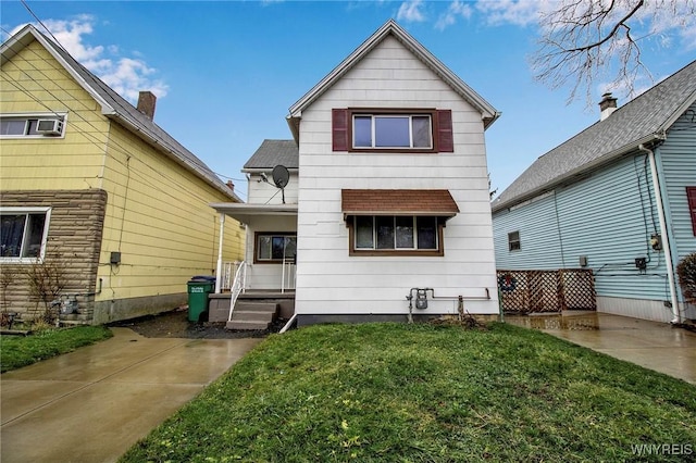 rear view of house featuring covered porch and a lawn