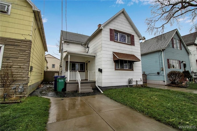 exterior space featuring covered porch and a front yard