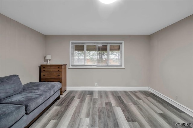 living area featuring baseboards and wood finished floors