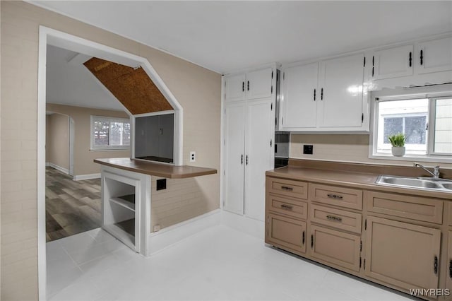 kitchen featuring arched walkways, plenty of natural light, and a sink