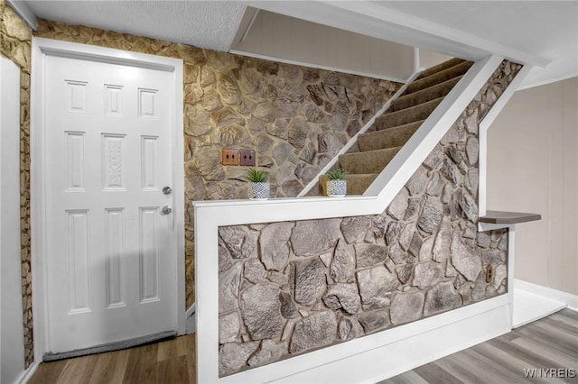 foyer with a textured ceiling and wood finished floors