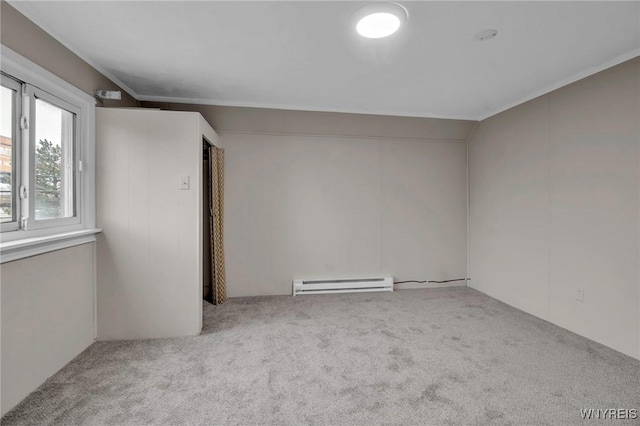 empty room featuring carpet flooring, baseboard heating, and ornamental molding