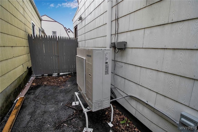 exterior details featuring ac unit and fence