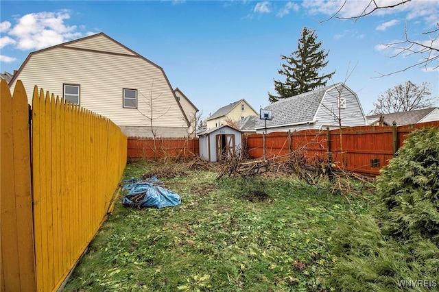 view of yard featuring an outbuilding, a fenced backyard, and a shed