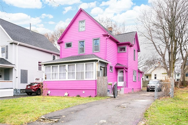 view of front facade with a sunroom and a front yard