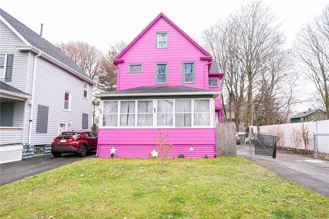 view of front of house with a sunroom and a front yard