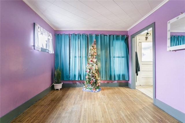 interior space with wood-type flooring, plenty of natural light, and ornamental molding