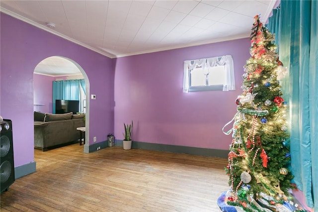 spare room with hardwood / wood-style floors and crown molding