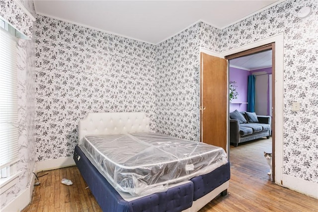 bedroom with wood-type flooring and ornamental molding