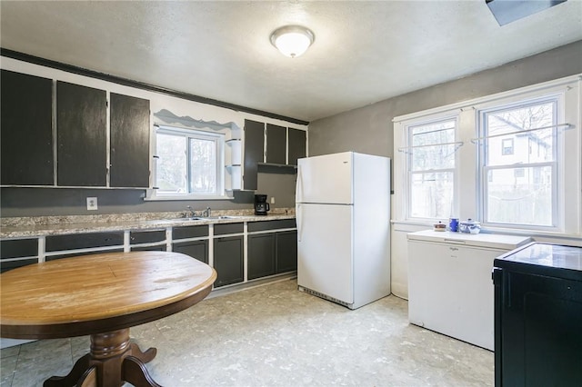 kitchen featuring white fridge, refrigerator, range, and sink