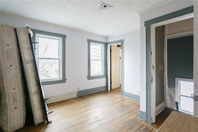 unfurnished bedroom with light wood-type flooring and crown molding