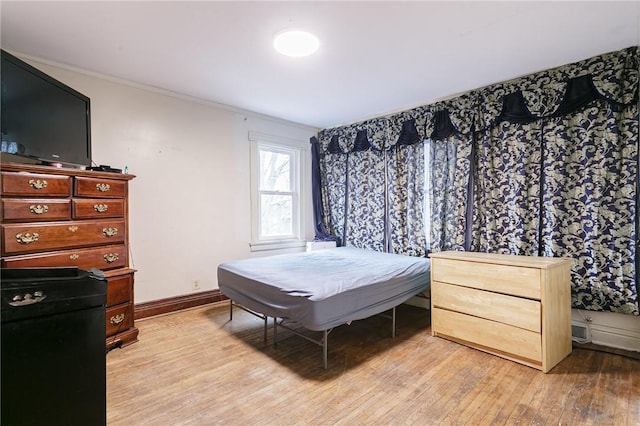 bedroom featuring light hardwood / wood-style flooring and ornamental molding