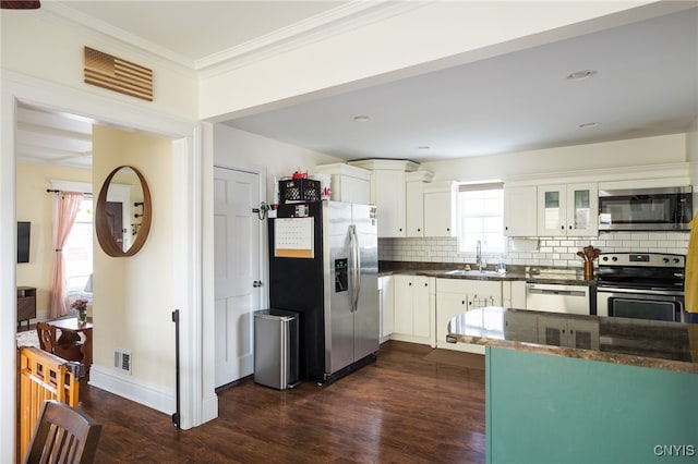 kitchen with dark wood-type flooring, white cabinets, sink, appliances with stainless steel finishes, and plenty of natural light