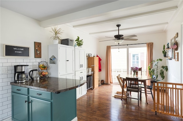 kitchen with kitchen peninsula, blue cabinets, ceiling fan, beamed ceiling, and dark hardwood / wood-style floors